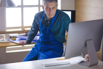 Engineer carpenter working on laptop and sketching project