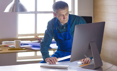 Engineer carpenter working on laptop and sketching project