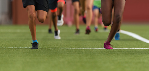 Running youth, young athletes run in a kids run race, running on grass detail on legs, running in the light of morning