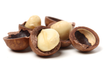Shelled and unshelled macadamia nuts on white background 