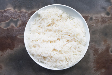 Steamed rice in a dish on an old iron table.