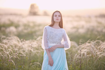 Fototapeta na wymiar girl walk in the field against the sunset, the bride against the sunset