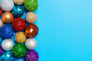 Festive composition of decorative baubles on colorful background. Top view of Christmas toys with copy space