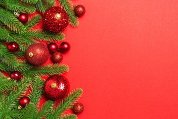 Christmas composition made of fir tree, balls and different decorations on colorful background. Top view of New Year Advent concept with empty space for your design