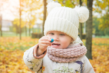 Little beautiful happy two year old girl in autumn park portrait