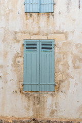Old window with wooden light green painted shutters