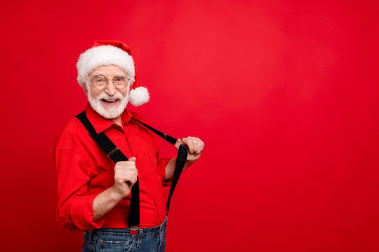 Portrait of his he nice trendy funny cheerful cheery glad bearded Santa Claus pulling suspenders having fun copy space isolated over bright vivid shine vibrant red background