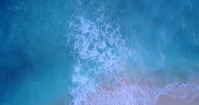 Sea With Waves Breaking, White Foam And Beach Sand Dragged Into The Sea, background shot with copy space