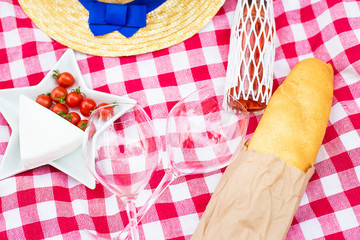Fototapeta premium hat, glasses, bread and cheese on red tablecloth