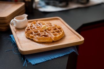 waffles with butter on wooden plate
