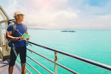 Naklejka premium Handsome man with a map looking to destination on holiday while travel on cruise ship