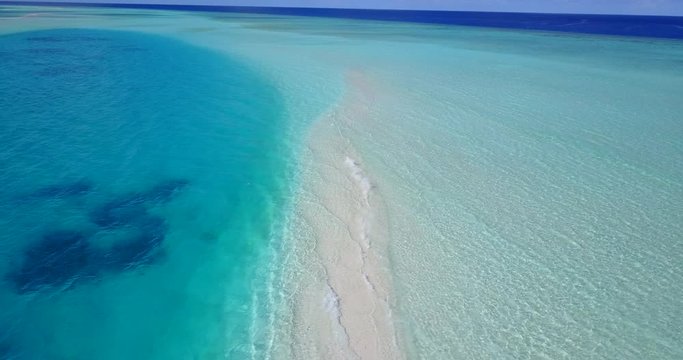 Absolutely breathtaking drone footage of a small sandbar crossing two bodies of crystal clear turquoise water in the Caribbean 4K