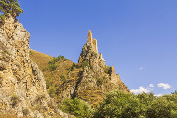 An ancient impregnable stone castle built on the pinnacles of steep rocky cliffs.Caucasus.