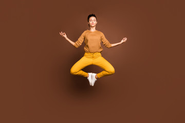 Fototapeta na wymiar Full length body size photo of jumping concentrated girlfriend having torn away from this world lost in dreams meditating clearing her chakra isolated over brown color pastel background