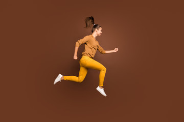 Fototapeta na wymiar Full length body size photo of cheerful positive cute nice charming sweet pretty sporty girlfriend hurrying to come to finish on time wearing yellow trousers isolated over brown pastel color