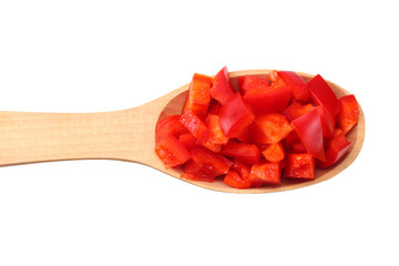 pieces of red sweet bell pepper in wooden spoon isolated on white background. top view