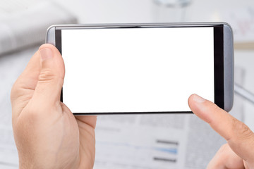 Smartphone mit leerem Display mit Zeitungen im Hintergrund