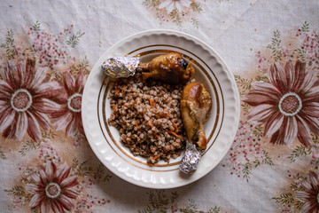 Baked chicken legs with buckwheat. Dish on an old rustic table. View from above