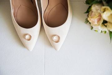 Beautiful beige wedding shoes and wedding rings - Powered by Adobe