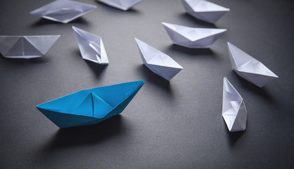 Blue and white paper boat. Leadership concept
