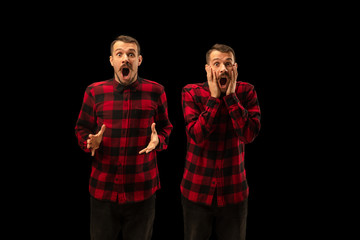Young handsome man arguing with himself on black studio background. Concept of human emotions,...