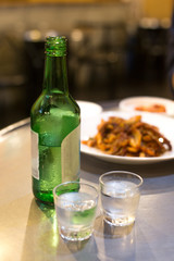 Soju bottle and small glass cup. Alcoholic Clear Distilled Korean Soju.
