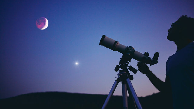 Astronomer with a telescope watching at the stars and Moon. My astronomy work.