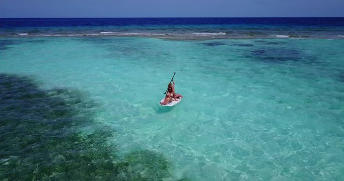 Two girls on a surfboard in a clear Caribbean sea