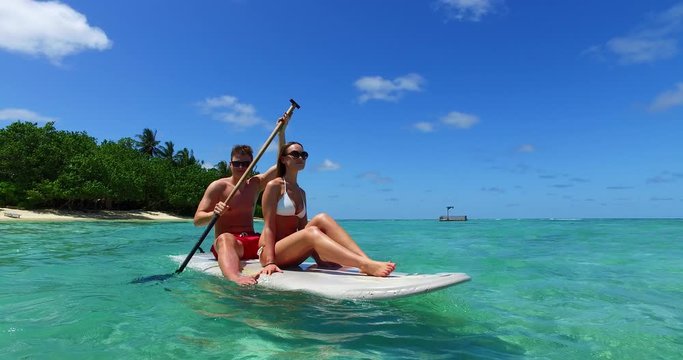 beautiful young couple on a paddleboard in Thailand