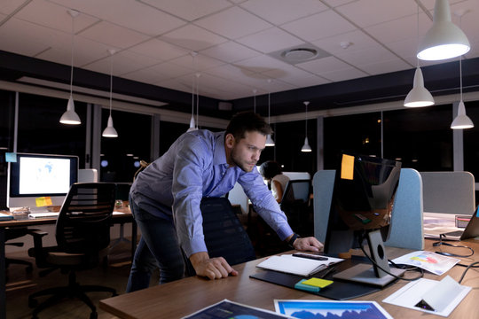 Young male professional working late in creative office 