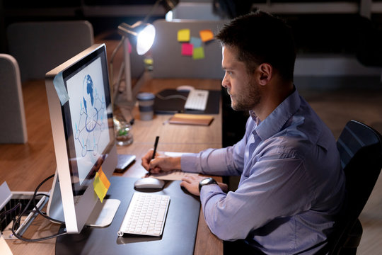 Young male professional working late in creative office