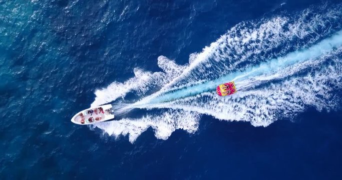 Aerial Drone Footage Of A Speed Boat Water Tubing In Clean Waters Of Hawaii 4K