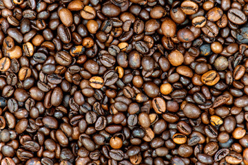 Texture background of coffee beans for design. Coffee grains scattered on the table