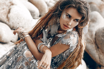 beautiful young woman with feathers in hair outdoors close up portrait