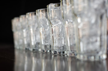 Glass of water that is filled with ice and arranged in rows.