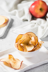 Apple chips in a white bowl on the table
