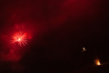 Awesome brilliant red fireworks above a illuminated church and against the backdrop of the night...