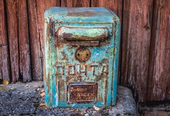 Rusty mail box in front of ruined post office in Zymovyshche, small village located in Chernobyl exclusion area, Ukraine