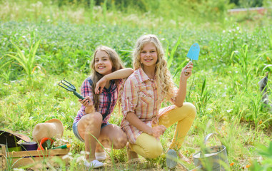 Agriculture concept. Growing vegetables. Planting vegetables. Summer activity. Sisters cute kids helping at farm. Girls planting plants. Planting and watering. Cheerful children working in garden