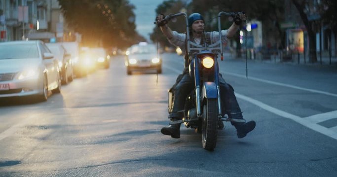 Motorcycle and cars are riding on street, ity during the sunset.