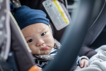Cute asian baby in child car seat going for a family road trip