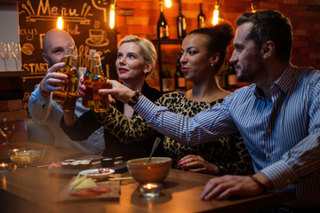Group of friends watching tv in a cafe behind bar counter