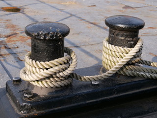 Fototapeta na wymiar Black bollards on the harbor wall for attachment to the ship