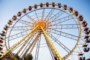 Fototapeta premium Ferris wheel and rollercoaster in motion at amusement park