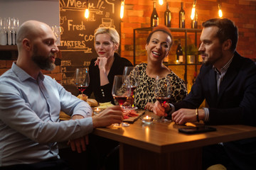 Group of friends having fun talk behind bar counter in a cafe