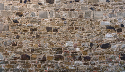 Alte grau braune Mauer aus vielen unterschiedlichen Steinen - aufgenommen in einer mittelalterlichen Klosteranlage