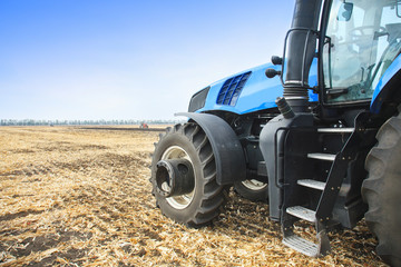 Obraz premium Modern tractor in the field during planting. The concept of agricultural industry. Copy space.