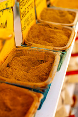 Dried kitchen herbs and different spices in boxes for sale in shop
