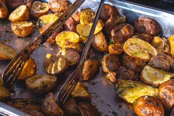 beautiful and tasty grilled fried potatoes with dill food court, distribution of food in metal dishes, festival food, dining room.