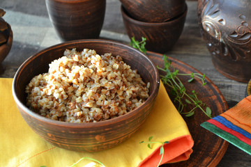 Buckwheat porridge in ceramic bowl on a rustic wood background